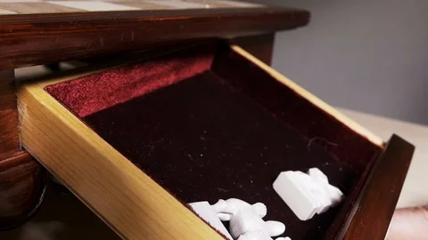 Many white closeup chess pieces fall and bounce in box slowmotion after match. Stock Footage 119347475