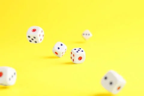 Many white game dices falling on yellow background. Space for text Stock Photos