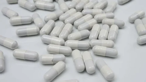 Many white pills, colored pill falling down Stock Footage 81261189