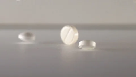 Many white pills falling white background.Macro Stock Footage 127620191