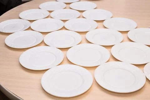 Many white plates on a table, pattern of dishes Foto stock