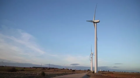 Many wind mills with rotating wings in an opened landscape with blue sky Stock Footage 141186171