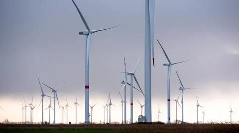 Many Wind Turbines, Generators in dramatic light, cloudy sky Stock Photos