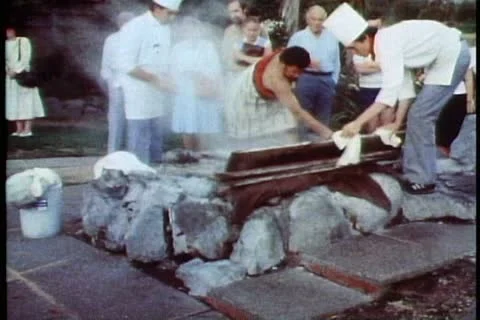 Maori feast, taking pig from steam oven in ground, wide shot Stock Footage