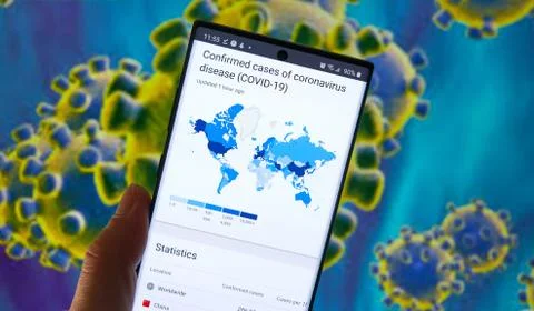 Map of confirmed cases of coronavirus worldwide on a Note 10 screen over bact Stock Photos