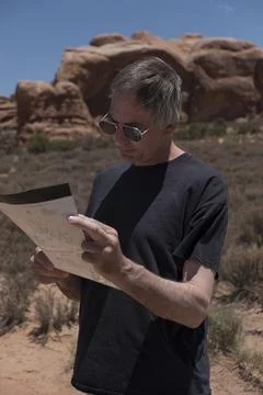 Map consults map before going on a hike, Moab, UT Stock-Fotos