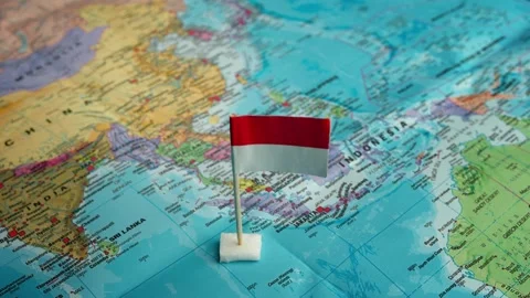 Map marking Indonesia, Closeup view of map with hand placing flag representing Stock Footage 327599051
