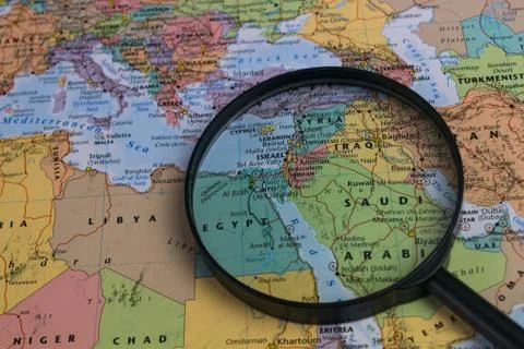 Map of Middle East through magnifying glass on a world map. Stock Photos