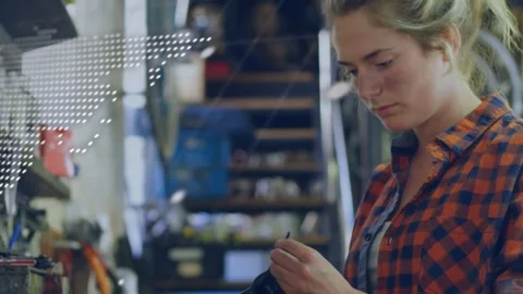 Map or code overlay appearing and causing woman grabbing tool, checking part at Stock Footage 332504952