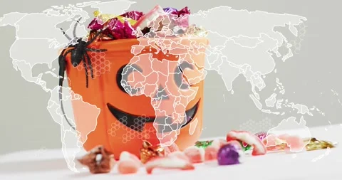Map outline fading over jack-o-lantern candy bucket, pulsing network Video stock 317791767