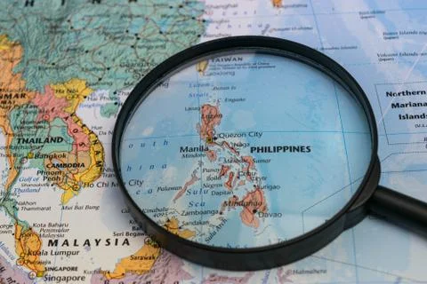 Map of the Philippines through magnifying glass on a world map. Stock Photos