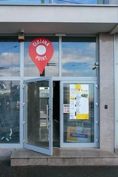 Map pointer affixed to the front entrance of a modern business building in Cluj Stock Photos