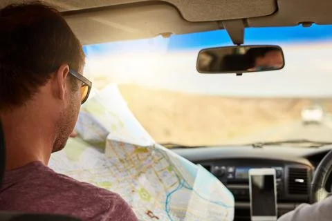 This map seems simple enough. two young friends reading a map while driving in Stock Photos