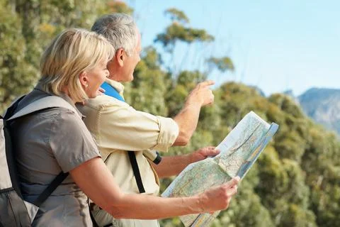 Map, trekking and pointing with old couple in nature for landmark direction Stock Photos