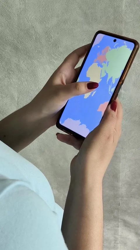 Map of the world on the phone screen in the hands of a woman Stock Footage 334794492