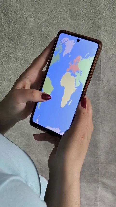Map of the world on the phone screen in the hands of a woman Stock Footage 334794595