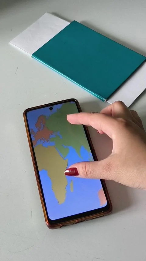 A map of the world on the phone screen in the hands of a woman Stock Footage 334794771
