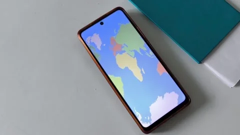 A map of the world on the phone screen on the table 動画素材 334794989