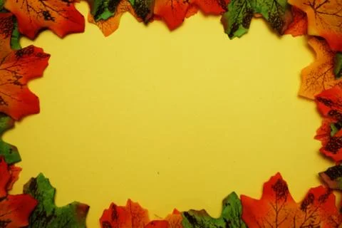 Maple autumn leaf border over on yellow background Stock Photos