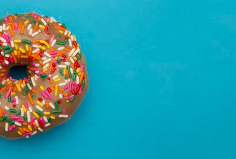 Maple Flavored Sprinkle Donut on a Blue Background Stock Photos