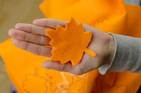 Maple leaf from orange felt in a woman's hand Stock Photos