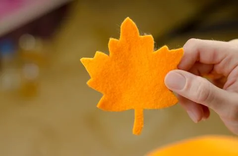 Maple leaf from orange felt in a woman's hand Stock Photos