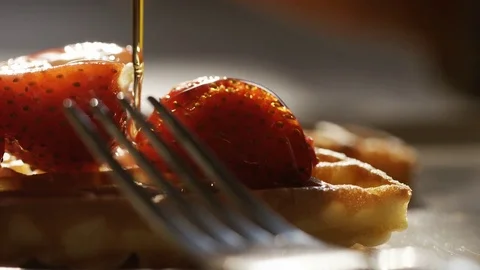 Maple syrup being drizzled over waffles and strawberries, in slow motion Stock Footage 74220771
