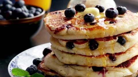 Maple Syrup being poured onto blueberry's and a stack of American pancakes. Stock-Footage 336589247