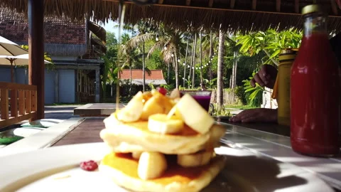 Maple Syrup being poured over breakfast pancakes in the sun, Bali, HD Stock Footage 158598698