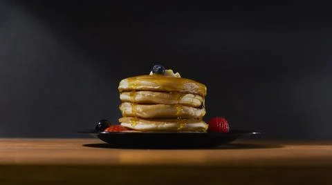 Maple syrup covered pancakes with fruit Stock Photos