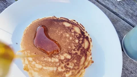 Maple syrup pouring onto a stack of pancakes for breakfast Stock Footage 329889629