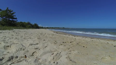 Mar quebrando na areia de praia na Bahia, com céu azul de fundo. Stock Footage