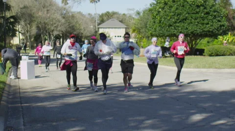 Marathon  group running and acknowledging crowds, Slow motion Stock Footage 62200102