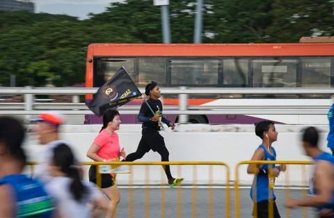 Marathon runner with team flag. Stock Photos