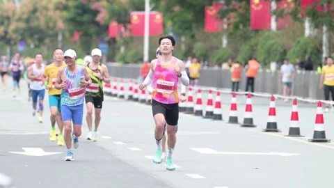 Marathon Runners Approaching Along Rows of Traffic Cones 스톡 동영상 348071506