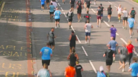 Marathon Runners Jogging Away from Camera. In Camera Stop Motion Slow Shutter Stock Footage 346650931