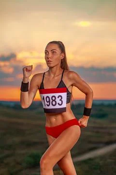 Marathon trail running. Sprinter run. Strong athletic woman running on black Stock Photos