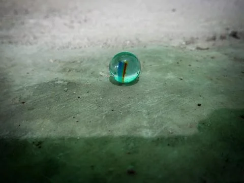 A marble on a cement floor Stock Photos