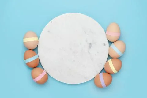 Marble circle with decorated eggs on blue background Stock Photos
