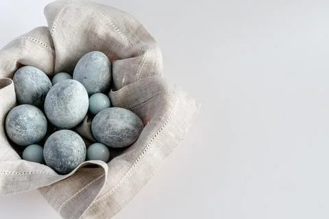 Marble-colored Easter eggs in a basket with a linen napkin on a white backgro Foto stock