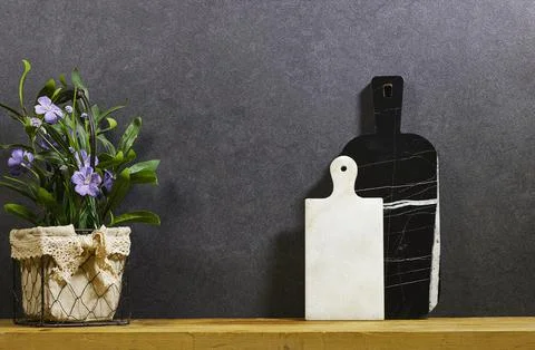 Marble Cutting Boards With Rustic Potted Purple Flowers on Wooden Shelf Against  Stock Photos