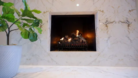Marble fireplace with glowing logs and warm flames, complemented by a stylish Vídeo Stock 324249917
