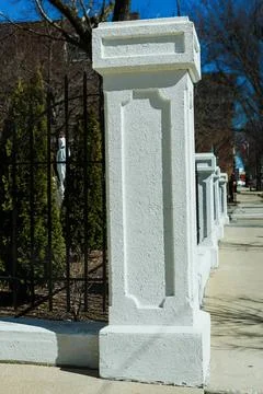 Marble mailbox on sidewalk with trees and fence Stock Photos