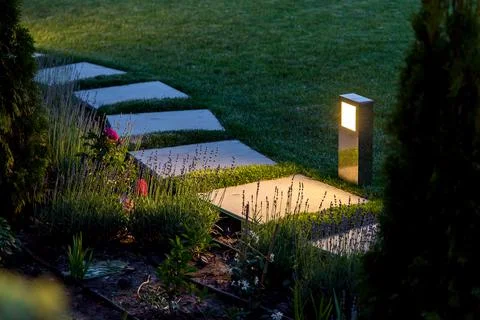Marble path of square tiles illuminated by a lantern made of metal glowing. Stock Photos