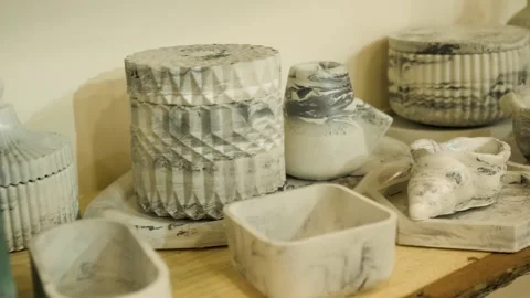 Marble patterned concrete jars textured ceramic vases on rustic wooden shelf Stock Footage 330477853