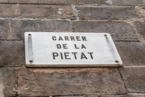 Marble rectangular sign with the name of the Carrer de la Pietat street Stock Photos