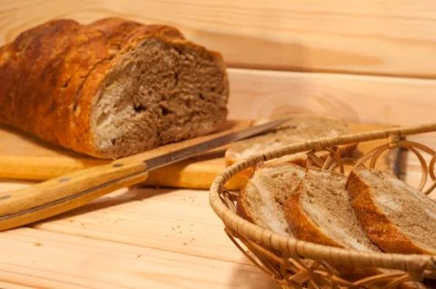 Marble sliced ??wheat - rye bread on a wooden board with a straw basket and s Stock Photos
