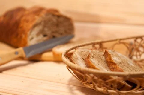 Marble sliced ??wheat - rye bread on a wooden board with a straw basket and s 스톡 사진
