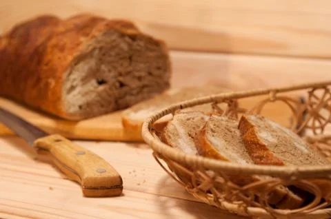 Marble sliced ??wheat - rye bread on a wooden board with a straw basket and s Stock Photos