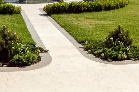 Marble stone walking path and stone edge with lawn green grass. Stock Photos